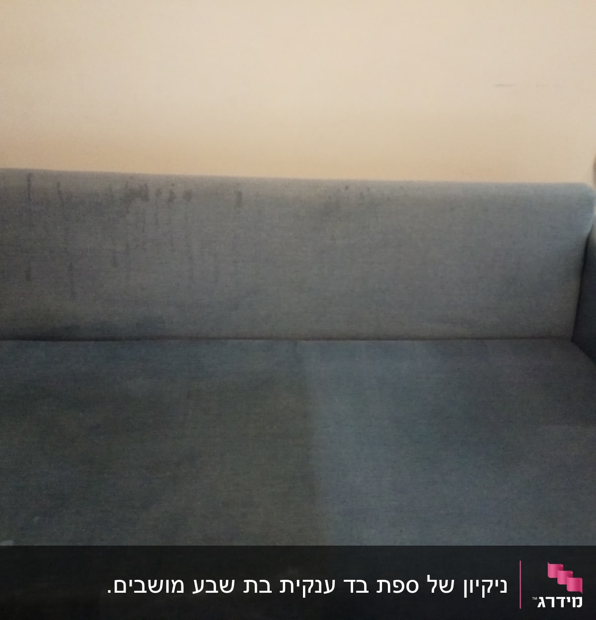 ספה כחולה עם כתמים על המושב והמשענת